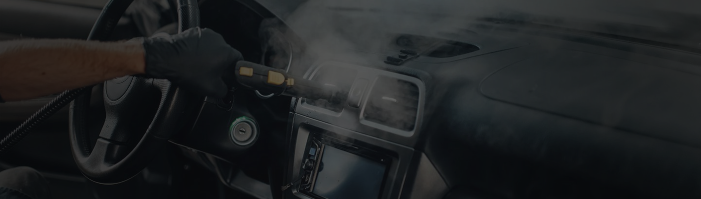 Image depicts a man cleaning the interior of a car.